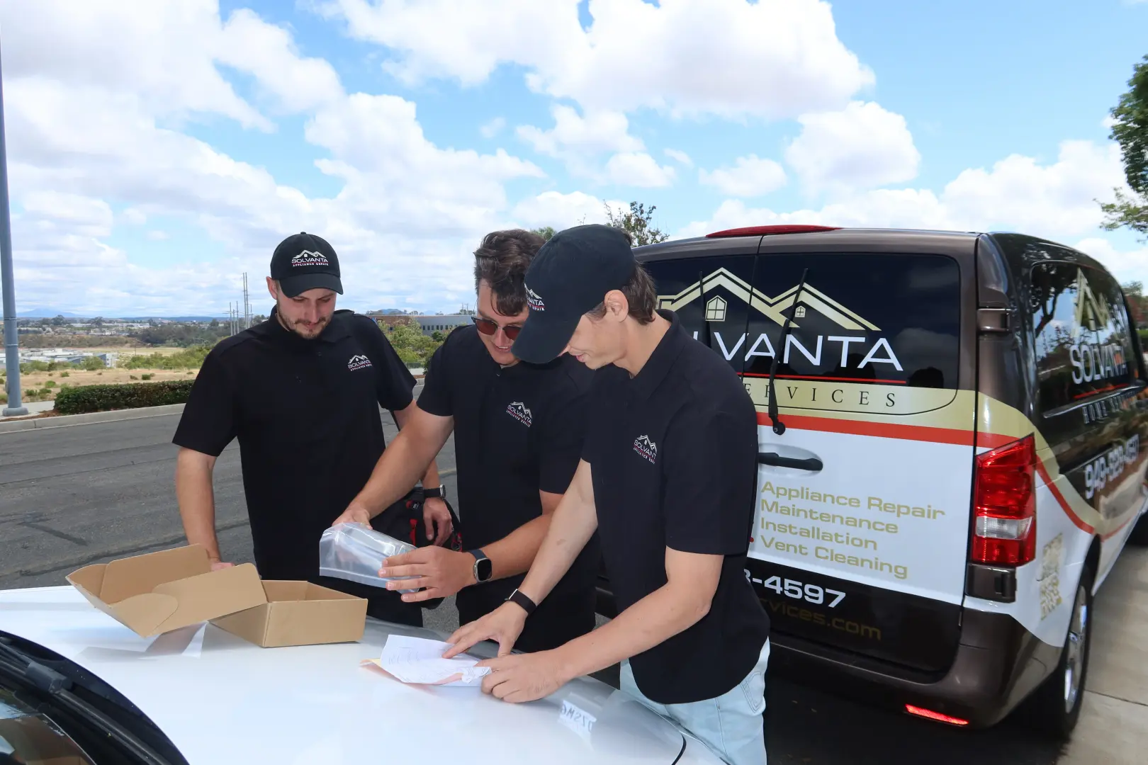 Solvanta Home Services team unpacking a replacement part